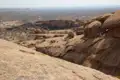 Felsige Landschaft mit verstreuten Büschen und Felsformationen.