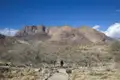 Wanderer auf einem Bergpfad in einer trockenen Landschaft.