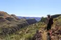 Wanderer auf einem Bergpfad mit Blick auf eine tiefe Schlucht.
