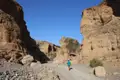 Person wandert durch eine felsige Schlucht.