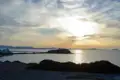Sonnenuntergang über dem Meer mit Inseln im Hintergrund.