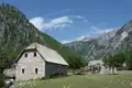 Steinhaus in einer bergigen Landschaft.