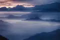 Sonnenaufgang über einer nebligen Berglandschaft.