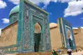 Türkisfarbene Mosaikfassade eines Mausoleums mit kunstvollen Mustern und Verzierungen.