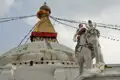 Weiße Elefantenstatue vor einer Stupa mit den Augen Buddhas.