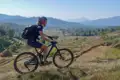 Mountainbikerin auf einem Bergpfad mit Blick auf terrassierte Felder.