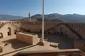 Innenansicht einer Festung mit architektonischen Details und Berglandschaft.
