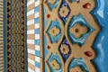 Nahaufnahme der Keramikfliesen mit blauen, roten, gelben und weißen Details.