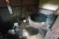 Traditionelles Onsen mit Steinwanne und Duscharmatur.