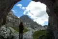 Wanderer in einer Höhle mit Blick auf die Berge.
