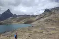 Wanderer am Ufer eines Bergsees inmitten einer Gebirgslandschaft.