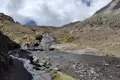 Wanderung durch eine Gebirgslandschaft mit Bachüberquerung.