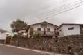 Außenansicht des Gästehauses mit Steinmauer und Balkon.