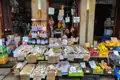 Marktstand mit verschiedenen Sorten getrocknetem Fisch wie Bacalhau, Graudo, Corronto und Cachacos, sowie Obst und Gemüse.