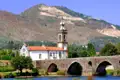 Historische Kirche und Steinbrücke in einer idyllischen Landschaft.