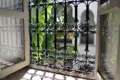 Blick durch ein traditionelles marokkanisches Fenstergitter auf einen Innenhof mit Bananenpflanzen.