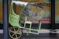 Historische Voiturette vor Werbeplakat von Moret & Lyon-Vaise.