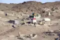 Gebäude und Ruinen in einer wüstenartigen Landschaft, möglicherweise Teil einer alten Siedlung.