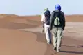 Zwei Wanderer durchqueren die Wüste.