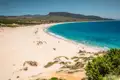 Panoramablick auf einen weißen Sandstrand und türkisfarbenes Meer.