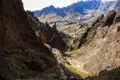 Wanderer auf einem Bergpfad in einer felsigen Schlucht.