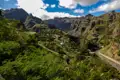 Panoramablick auf ein grünes Tal mit Berglandschaft.