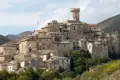 Panorama eines historischen Bergdorfes mit dichter Bebauung und einem dominierenden Turm in der Mitte.