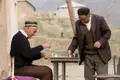 Zwei Männer spielen Schach an einem Tisch im Freien.