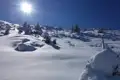 Schneebedeckte Landschaft unter blauem Himmel und Sonnenschein.