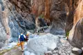 Wanderer durchqueren eine felsige Schlucht.
