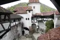 Blick auf den Innenhof der Burg mit seinen architektonischen Details wie den weißen Wänden, dem Fachwerk und den roten Ziegeldächern. Ein Brunnen befindet sich in der Mitte des Hofes.