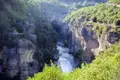 Flusslandschaft in einer Schlucht mit steilen Felswänden.