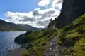 Wanderweg am Seeufer mit Blick auf die Berge.