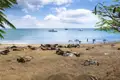 Strandansicht mit Booten und Menschen im Wasser.