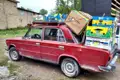 Rotes Auto transportiert Obstkisten auf dem Dach.