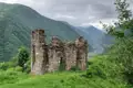 Alte Festungsruine mit Blick auf ein Tal in den Bergen.