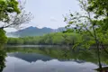 Ruhiger See mit Spiegelung der Berge und Bäume.