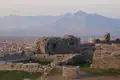 Blick von einer Burgruine auf die Stadt und die Berge.