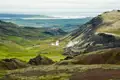 Geothermische Landschaft in Island mit Dampfquellen und Seeblick.