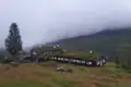 Begrünte Berghütte in den Bergen im Nebel.