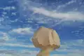 Eine ungewöhnliche Felsformation, die an einen Pilz erinnert, vor einem blauen Himmel mit weißen Wolken.