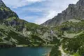 Panoramablick auf einen Bergsee und Wasserfall in den Bergen.