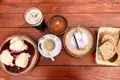 Eine Auswahl an traditionellen Speisen und Getränken, darunter Dampfnudeln, Mohnstrudel, Suppe und Brot, zusammen mit einem dunklen Bier und Kaffee.