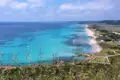 Türkisblaues Meer und Sandstrand an der Küste.