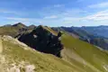 Berggipfel und -täler unter blauem Himmel.