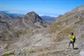 Wanderer auf einem Bergpfad inmitten einer felsigen Landschaft.