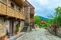 Historische Architektur eines Dorfes mit traditionellen Häusern, Holzbalkonen und gepflasterten Wegen.