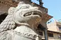 Steinskulptur eines Löwen, der einen Tempel bewacht.