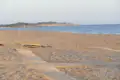 Sandstrand mit Holzsteg und Meerblick.