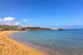 Goldener Sandstrand und türkisblaues Wasser einer malerischen Bucht.